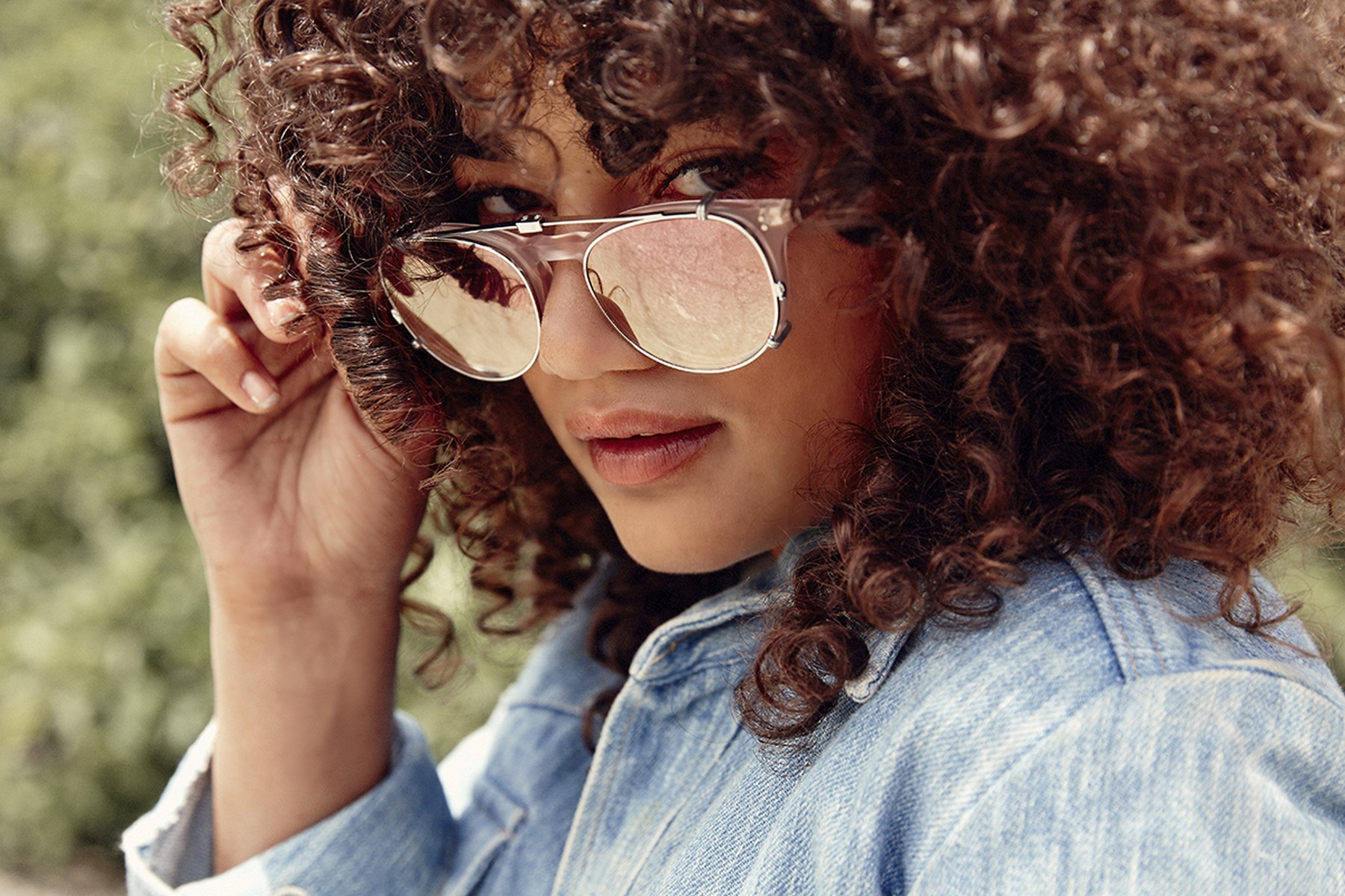 Brillenmarke Garrett Leight - Sehr lockige Frau mit runder Brille