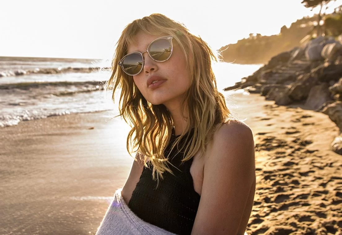 Brillenmarke Oliver Peoples - Frau am Strand mit Sonnenbrille