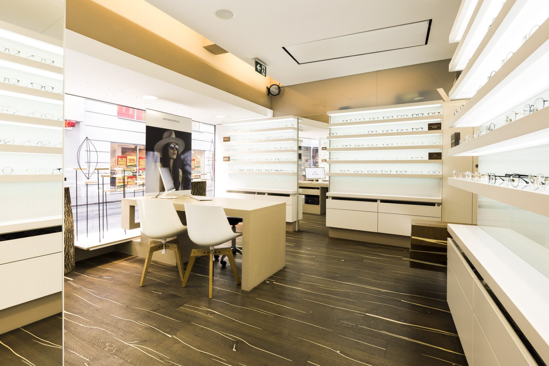 Optiker Graz - Sattler Optik - Shop - Innenansicht - Brillenregale, Stühle, Tisch