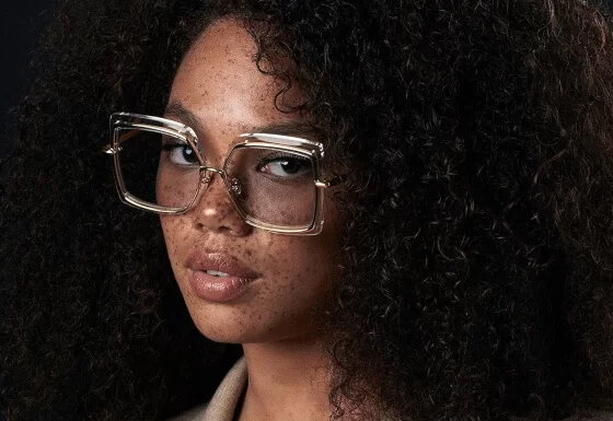 Brillenmarke Dita Eyewear - Frau mit Locken und Sommersrpossen trägt eckige Sonnenbrille